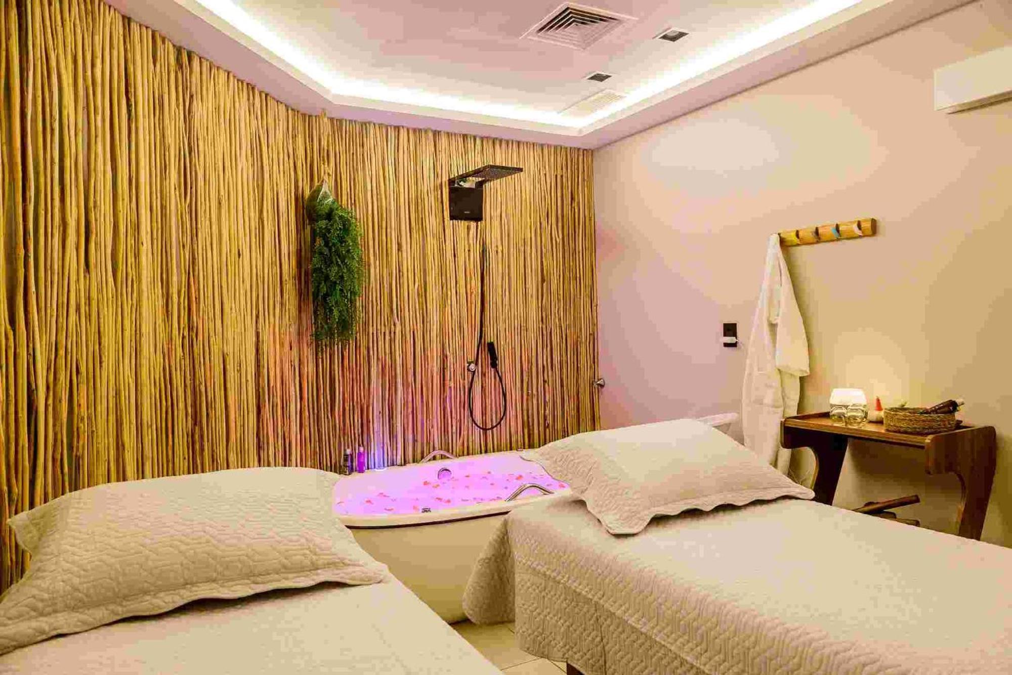 Hotel Luzeiros Sao Luis Eksteriør billede The photo shows a relaxing spa room designed for treatments. It features two massage beds with soft bedding, a large bathtub in the corner that has ambient purple lighting, and a shower overhead. The walls are decorated with bamboo panels, adding a n
