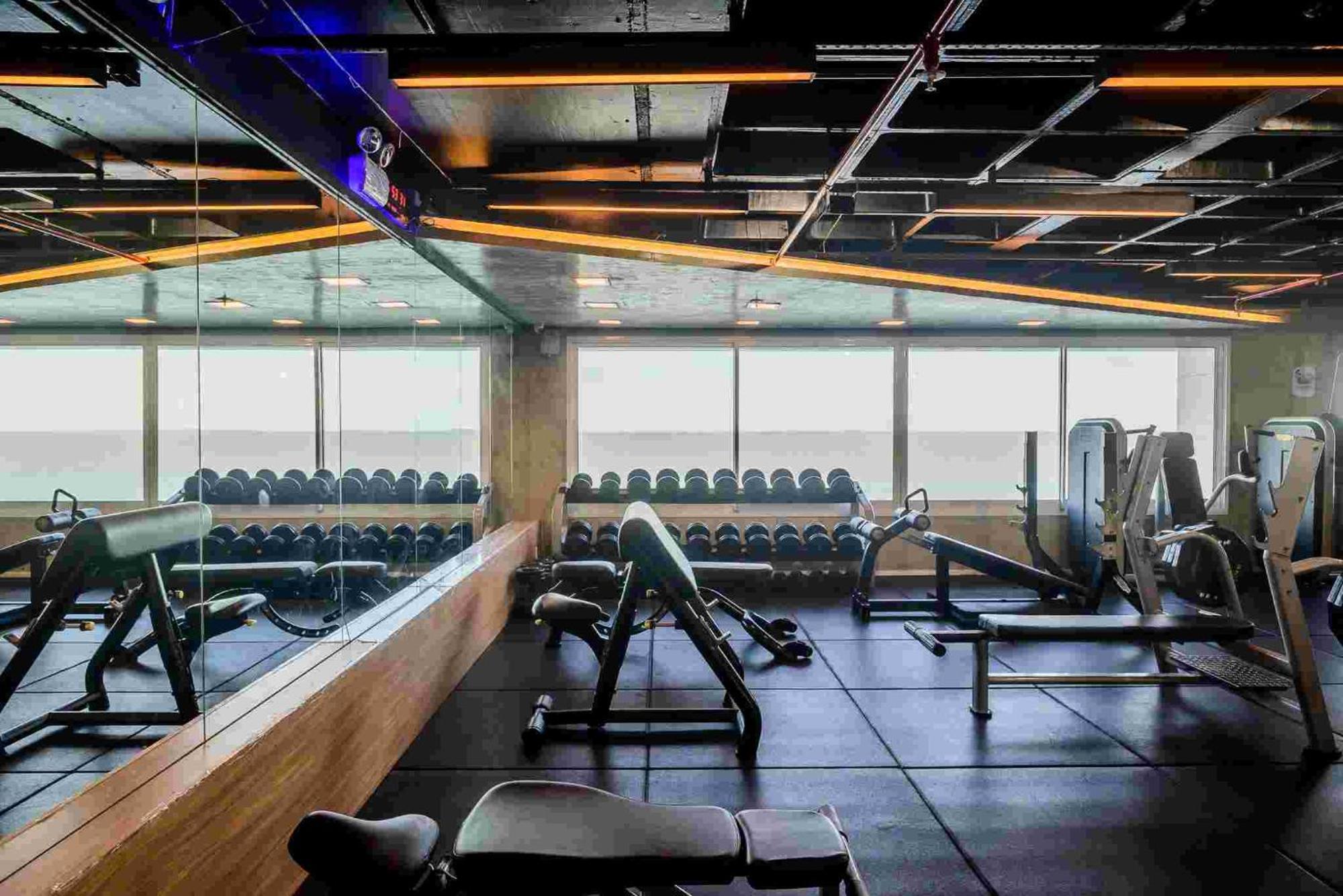 Hotel Luzeiros Sao Luis Eksteriør billede The photo shows a modern gym interior. There are several fitness machines and equipment, including free weights organized on shelves, weight benches, and exercise machines. The gym features large windows, allowing natural light to enter, and has a mi