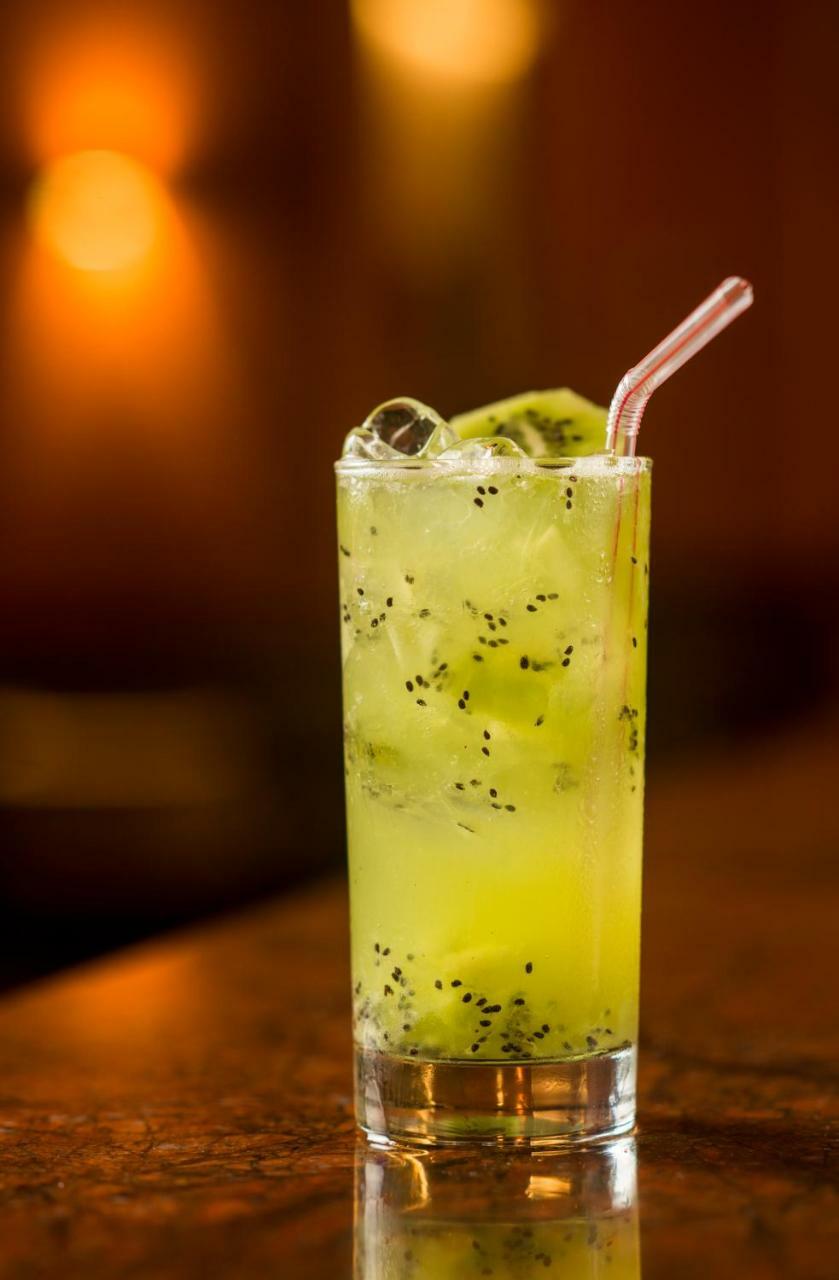 Hotel Luzeiros Sao Luis Eksteriør billede The image features a tall glass filled with a refreshing, green beverage. The drink is a light, vibrant green color and contains ice cubes, adding to its chill appeal. Floating within the drink are small black seeds, likely from a fruit ingredient. A